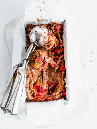 two scoops of peanut butter chocolate ice cream with raspberry pieces