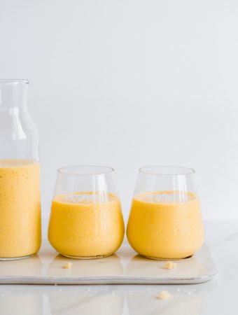 mango lassi in glasses topped with coconut flakes
